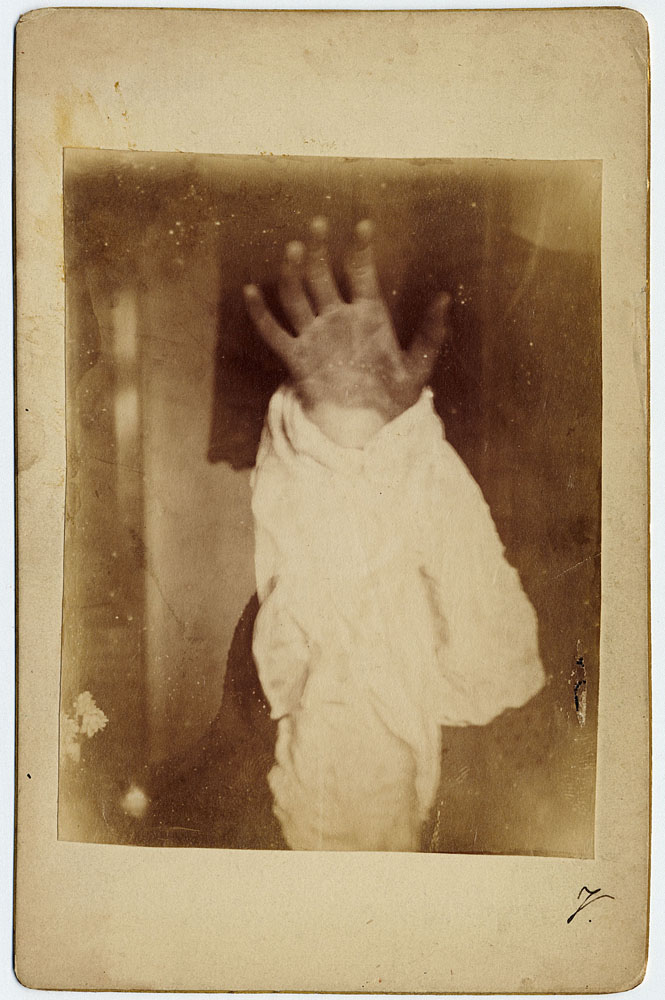 Photo showing hand draped in sheet reaching for viewer