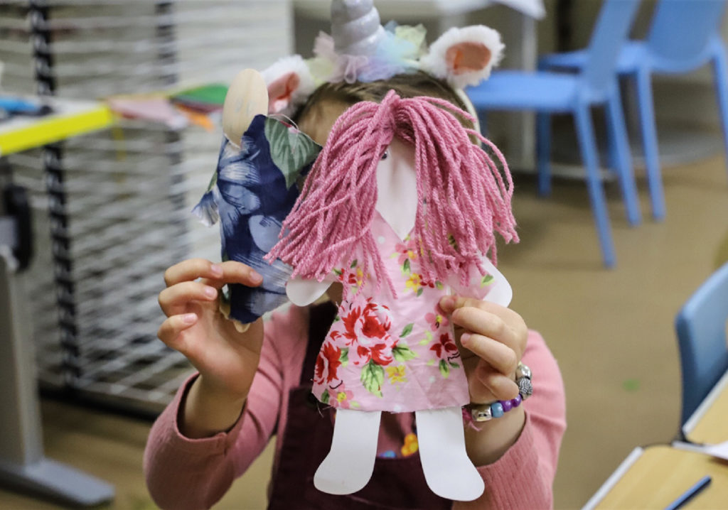 Doll held up by obscured child.