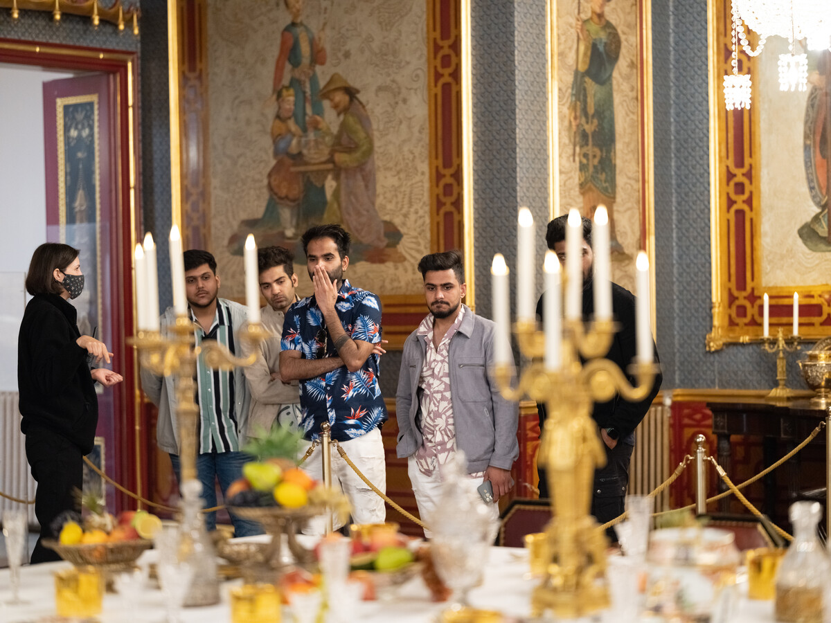 Visitors looking at table with candelabras and other items.