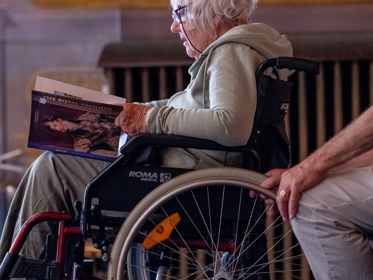 Person in wheelchair reading a guidebook.