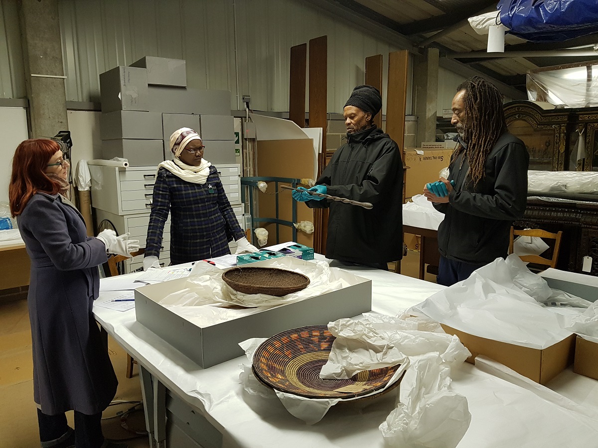 Group of people viewing museum artefacts on a table