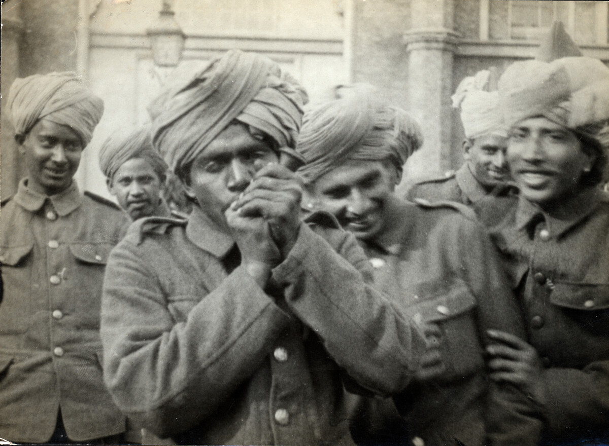 Group of Indian soldiers. One smokes a pipe while the others laugh.