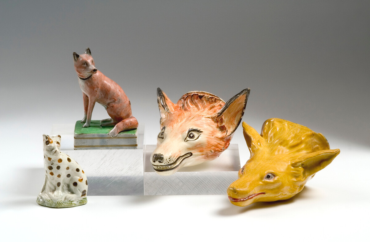 Four ceramic pieces in the form of animal heads.