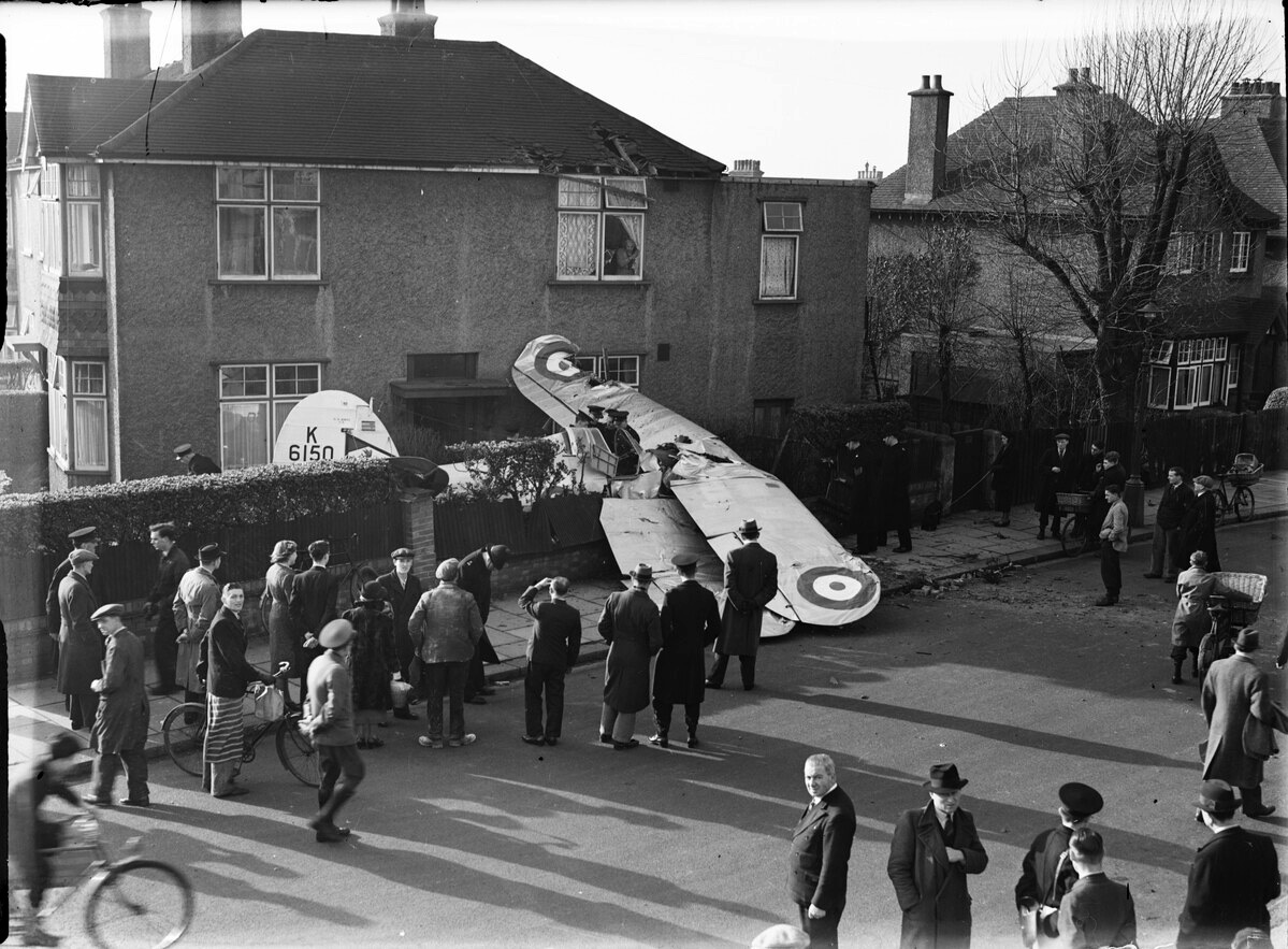 Photo showing old propeller plane that has crash landed in a street