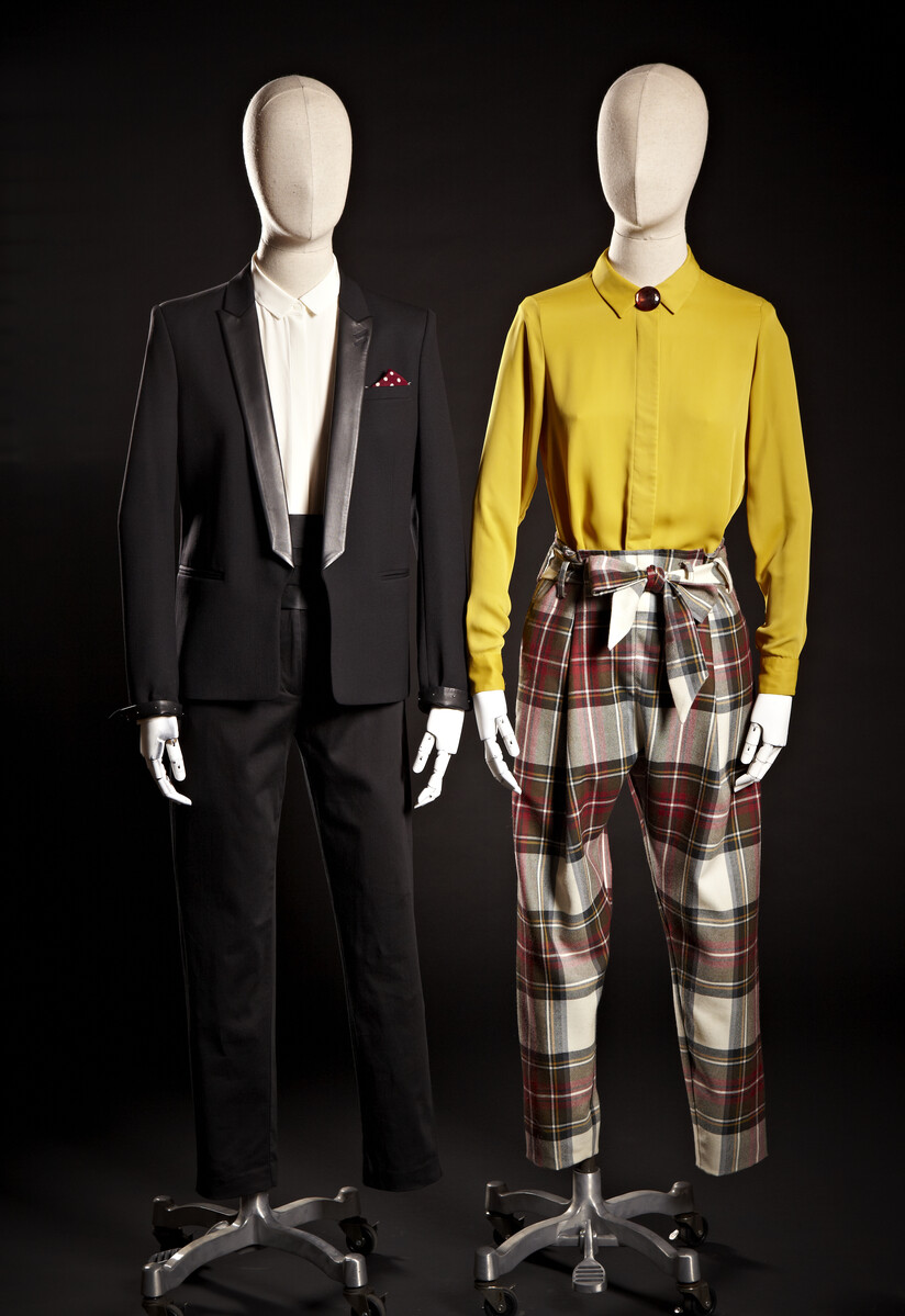 Two mannequins with clothing: one with a black tuxedo and the other with tartan trousers.