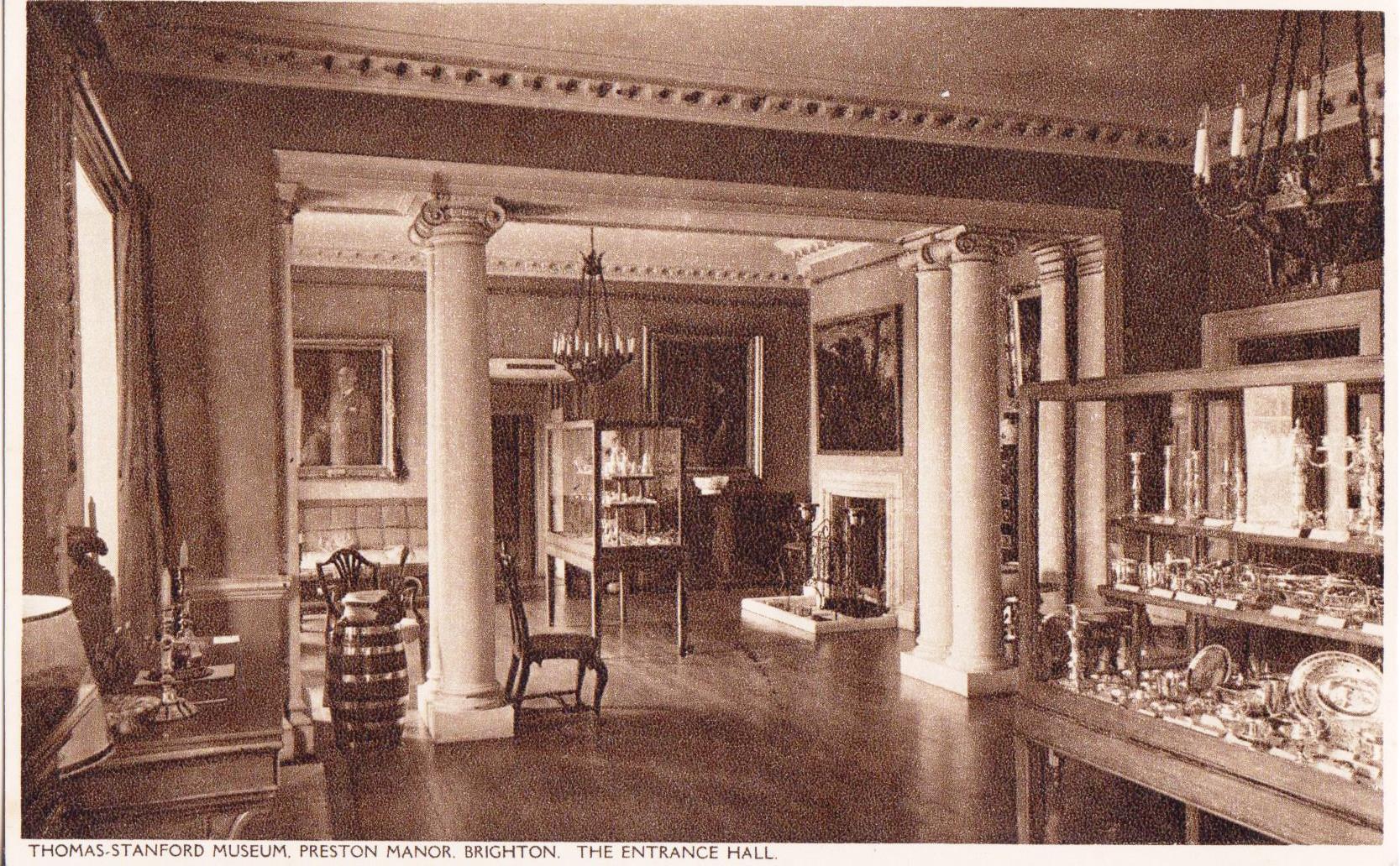 Postcard of Manor entrance hall showing silver in cases