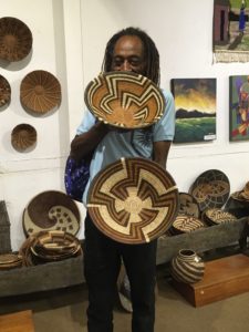 Tshepo Skwambane choosing baskets to purchase at Botswanacraft, Gaborone