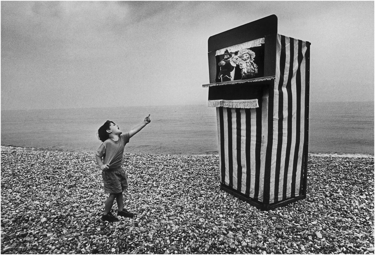 Image of a boy laughing at a Punch and Judy show on Brighton beach