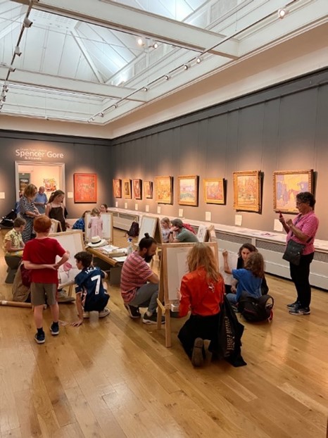 Easels set up in the Fine Art Gallery at Brighton Museum with adults and children painting
