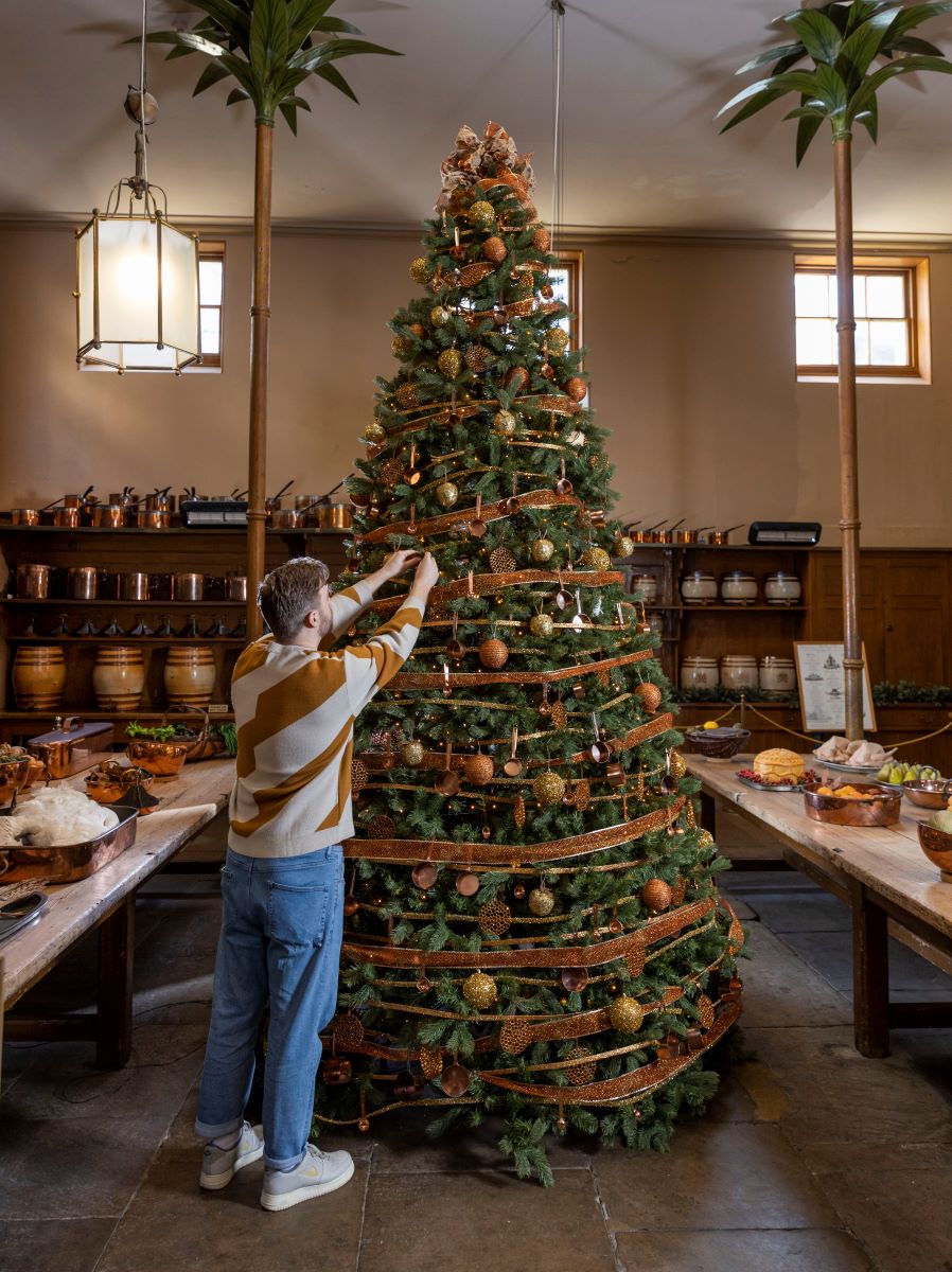 A member of the Royal Pavilion team is busy decorating a Christmas tree inside the great kitchen.