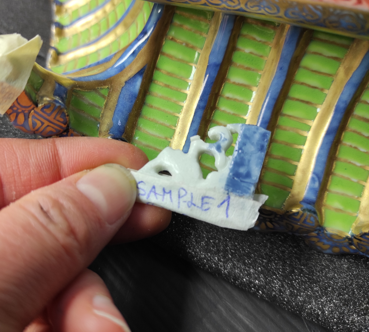 Test sample of blue colour on Hxtal epoxy resin reconstruction. a small piece of painted resin is held against the pagoda.
