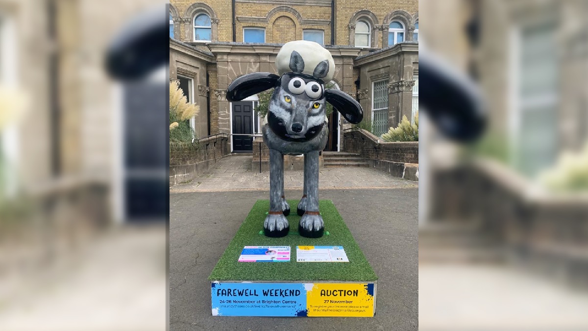 Wolf in Shaun’s clothing outside Hove Museum of Creativity. A life-size sheep sculpture painted to look like a wolf stands on an artificial grass plinth.