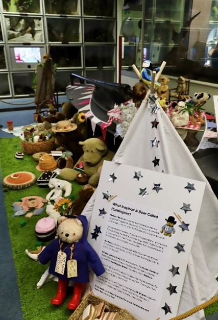 A Teddy Bear’s Picnic at the Booth Museum. Paddington Bear sits at the picnic next to a tent and a text panel about his story.