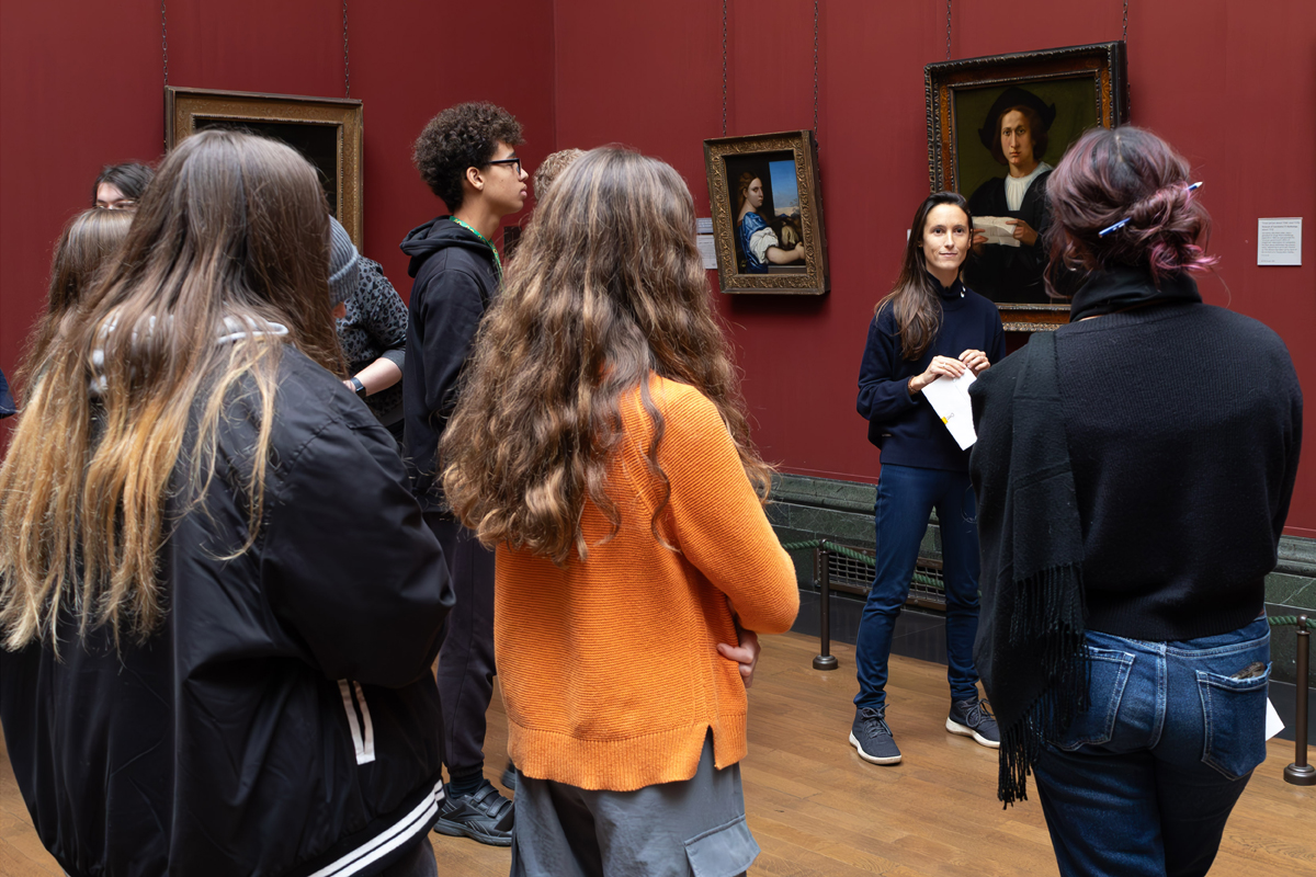 Photography Club's visit to the National Gallery. The Club stand in a gallery looking at portraits and listening to a woman speaking