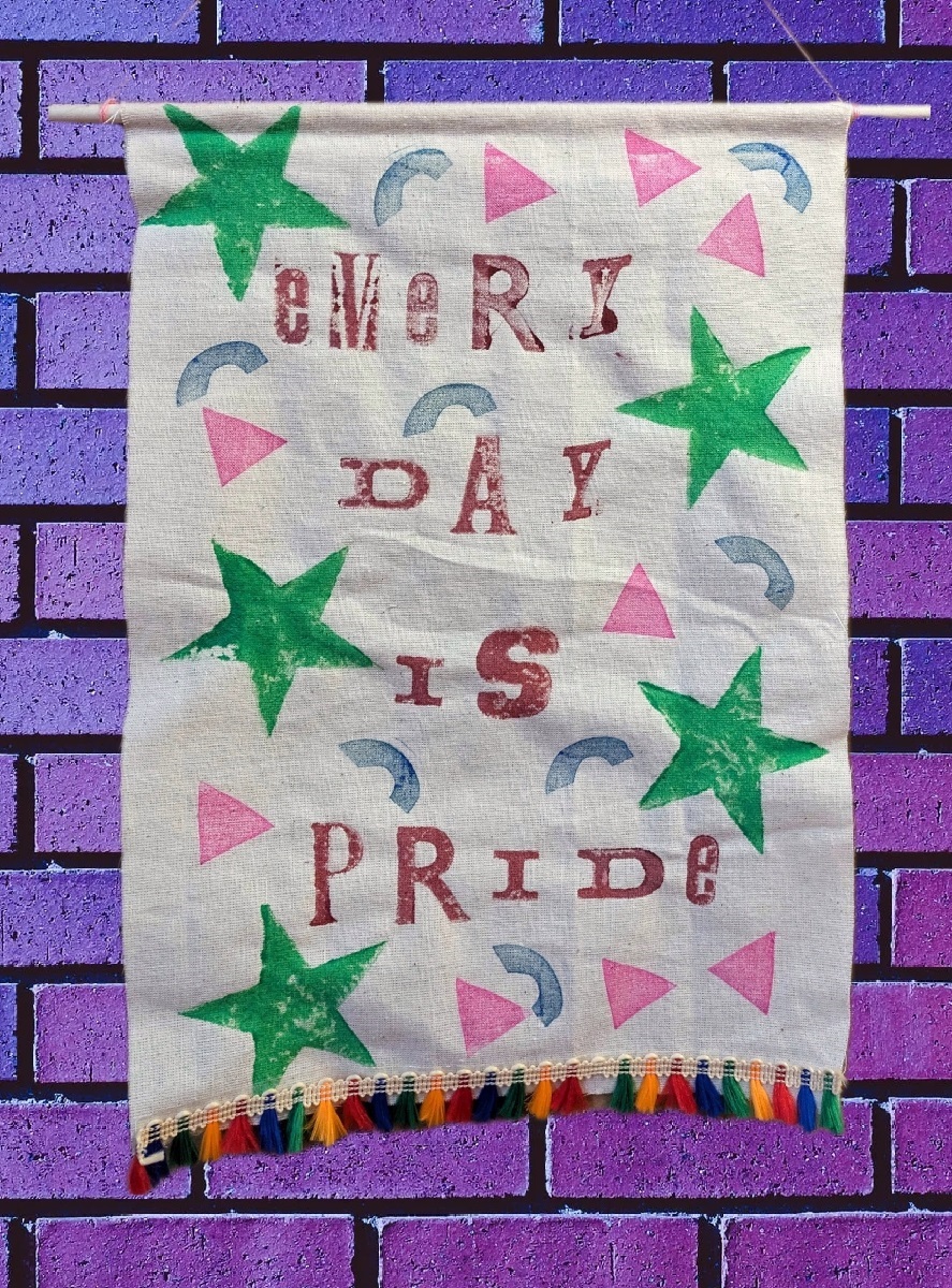 Banner for Pride, decorated with different coloured stars, triangles and semi circles it says Every Day is Pride