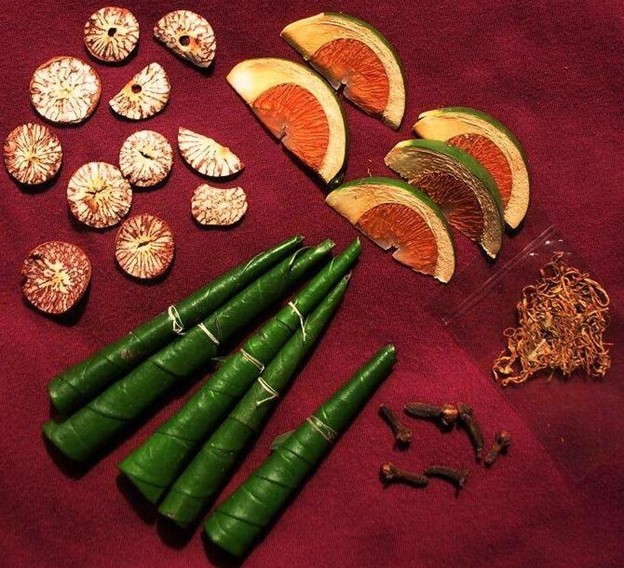 The items used in a chewing session. Left: dry areca nut slices; Right: tender areca nut slices; Bottom left: folded betel leaves; Pouch on the right has tobacco, an optional element; On the lower right, there are dried cloves. Image: Mohonu, Public domain, via Wikimedia Commons