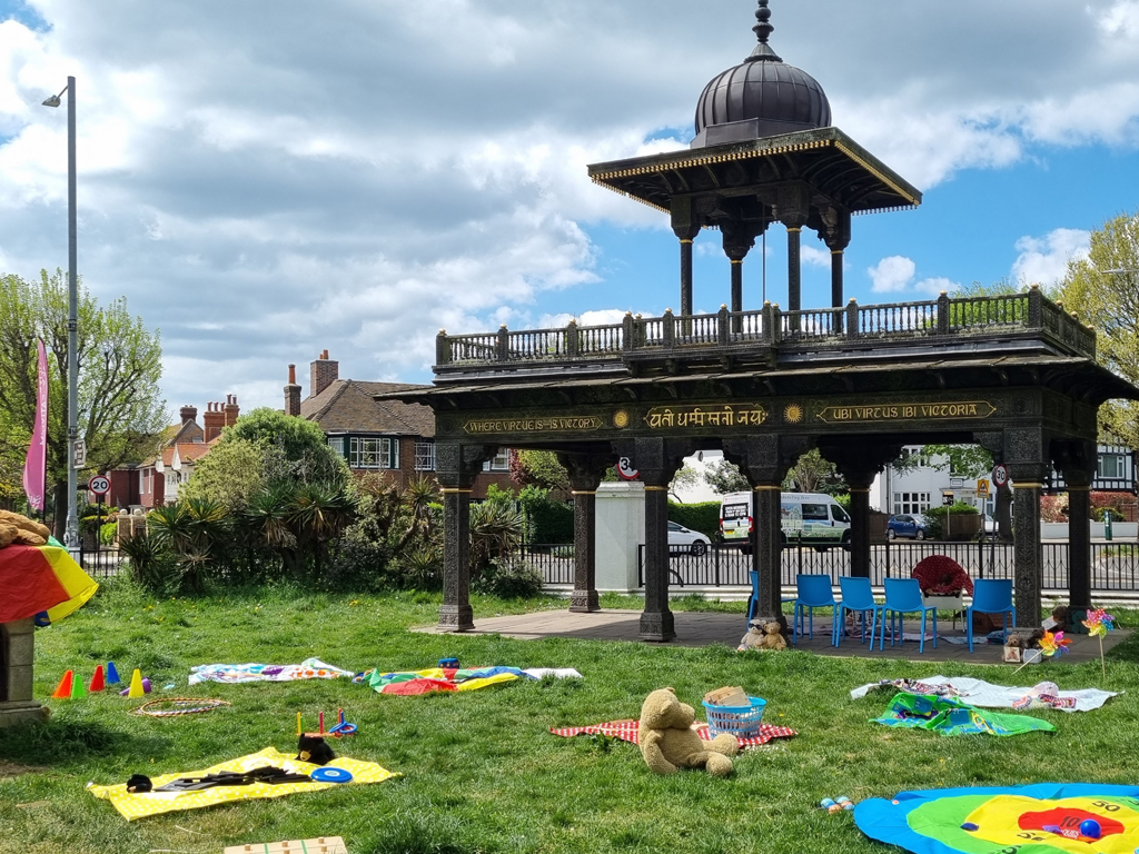 Play Days at Hove Museum. Books, toys and games are scattered over the grass outside of Hove Museum