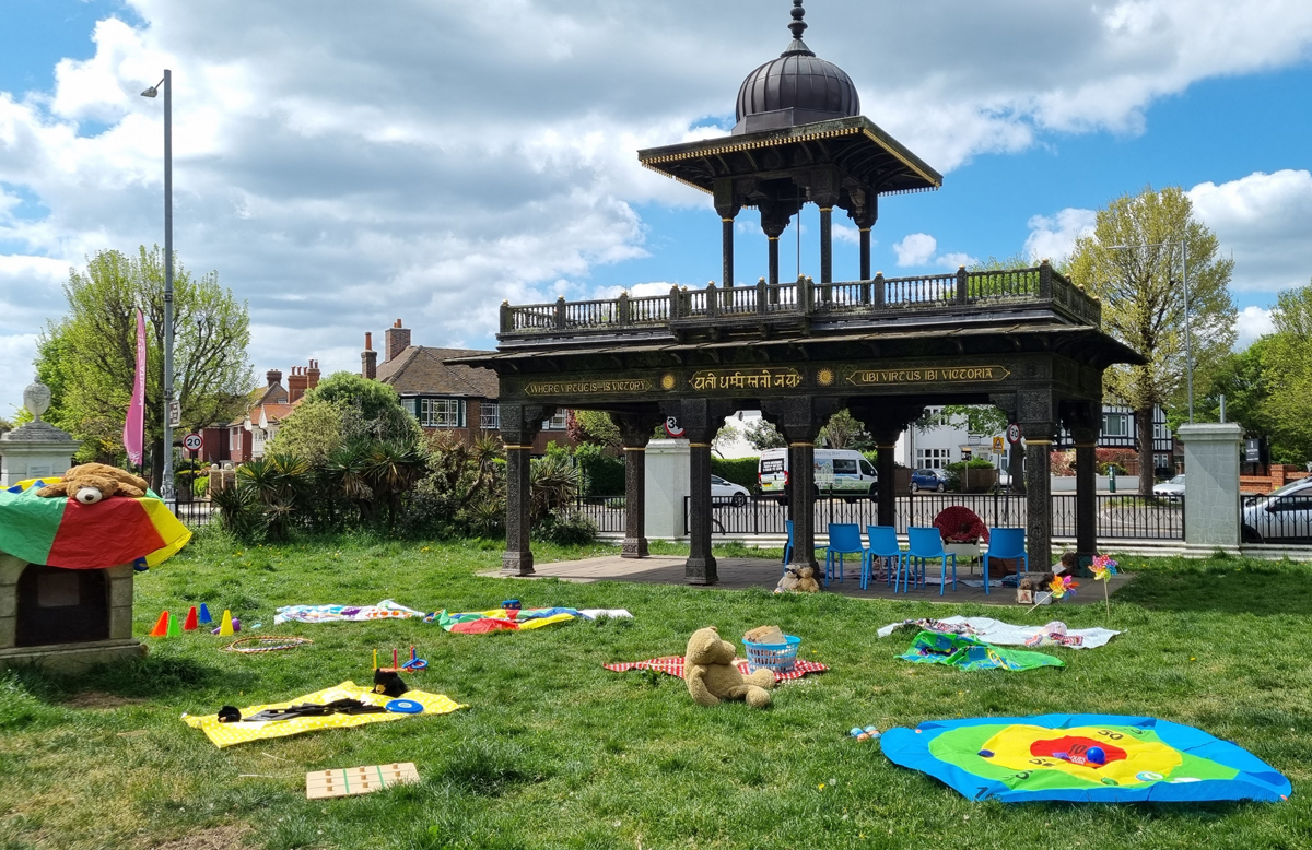 Play Days at Hove Museum. Books, toys and games are scattered over the grass outside of Hove Museum