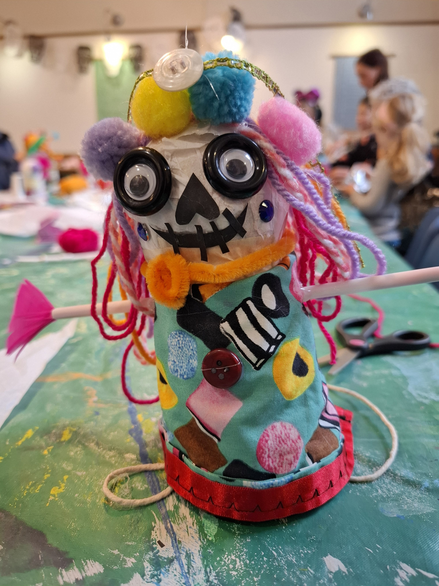 Art Club at Hove Museum. A Day of the Dead inspired puppet made from various art materials like paper, pompoms, string and buttons.