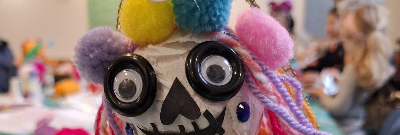 Art Club at Hove Museum. A Day of the Dead inspired puppet made from various art materials like paper, pompoms, string and buttons.