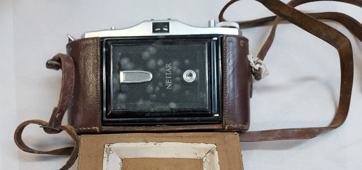 A camera in its leather bag covered in inactive mould. The bag, apart from the strap, was clean