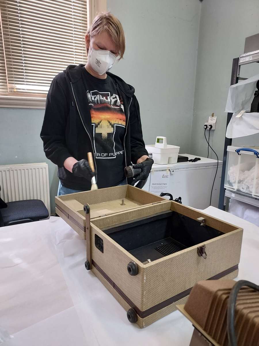 Íris cleaning a camera box of mould