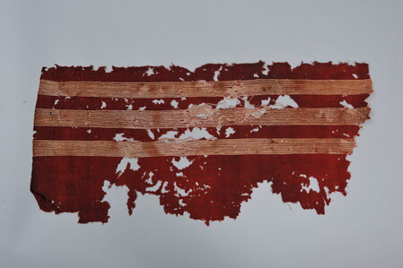 HA282036. Ancient Coptic textile, Islamic Period (641-1517CE), Hawara. Long piece red wool cloth with three stripes formed of white thread. Possibly a shawl.
