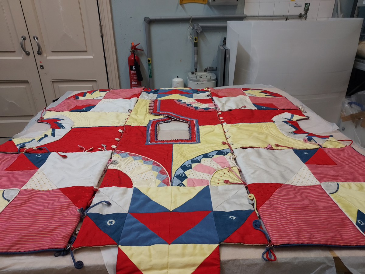 A jazzy quilted coat cover made of silk and cotton. Something in the red fabric was particularly attractive to mould