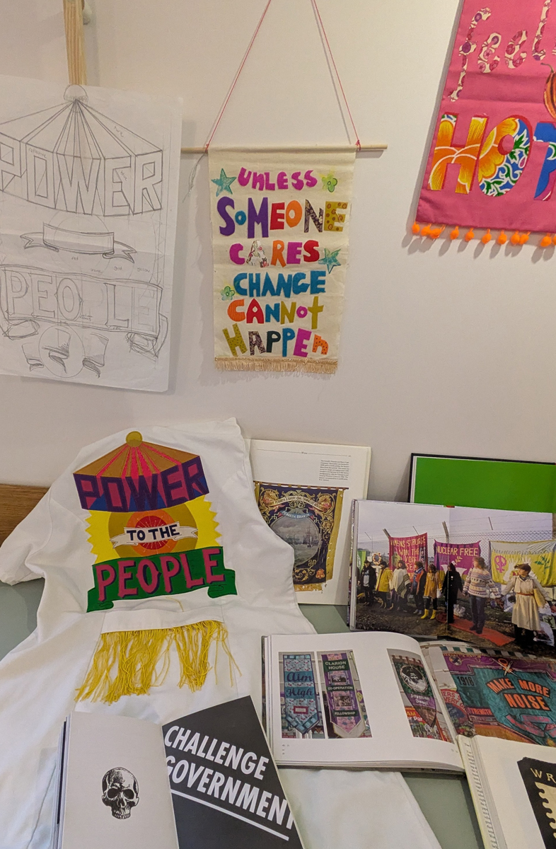 Power to the People session. Hand made banners, posters and books are displayed around a table
