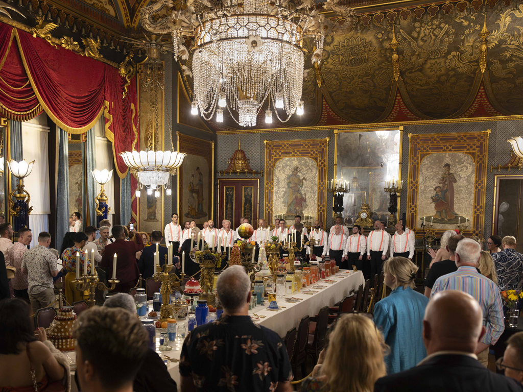 Pride at the Pavilion event 2025. The Banqueting Room of the Royal Pavilion is full of people standing, drinking and watching a choir
