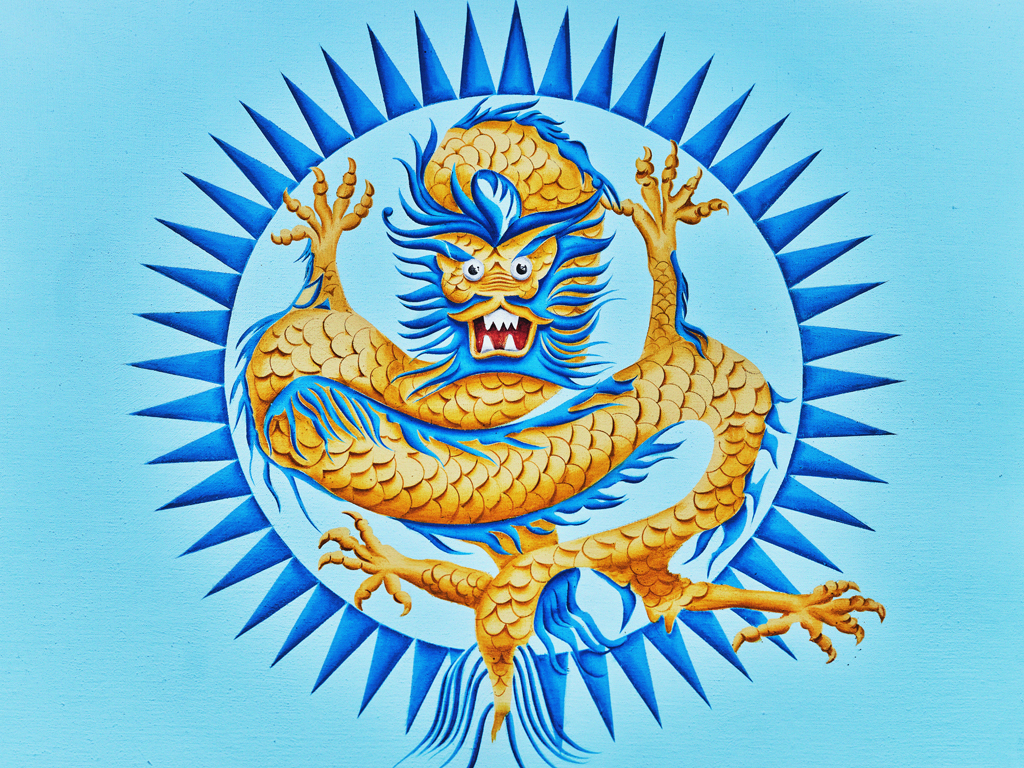 Designing Dragons- Craft Workshop. A pale blue background with a blue and yellow dragon enclosed in a dark blue circle with points facing outward.