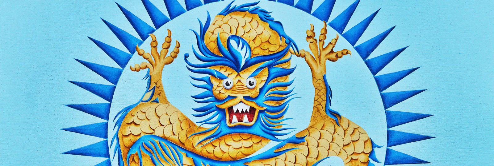 Designing Dragons- Craft Workshop. A pale blue background with a blue and yellow dragon enclosed in a dark blue circle with points facing outward.