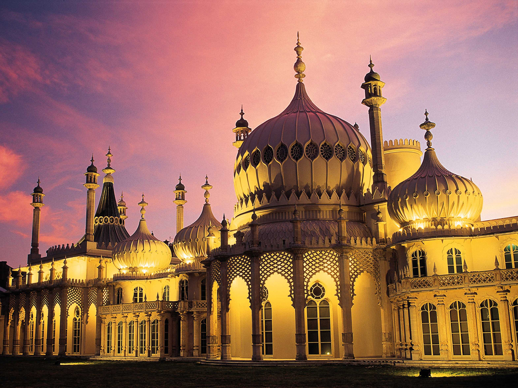 Royal Pavilion at Sunset. East Exterior view against a pink and pale blue sky. The Pavilion is lit by external yellow lightning