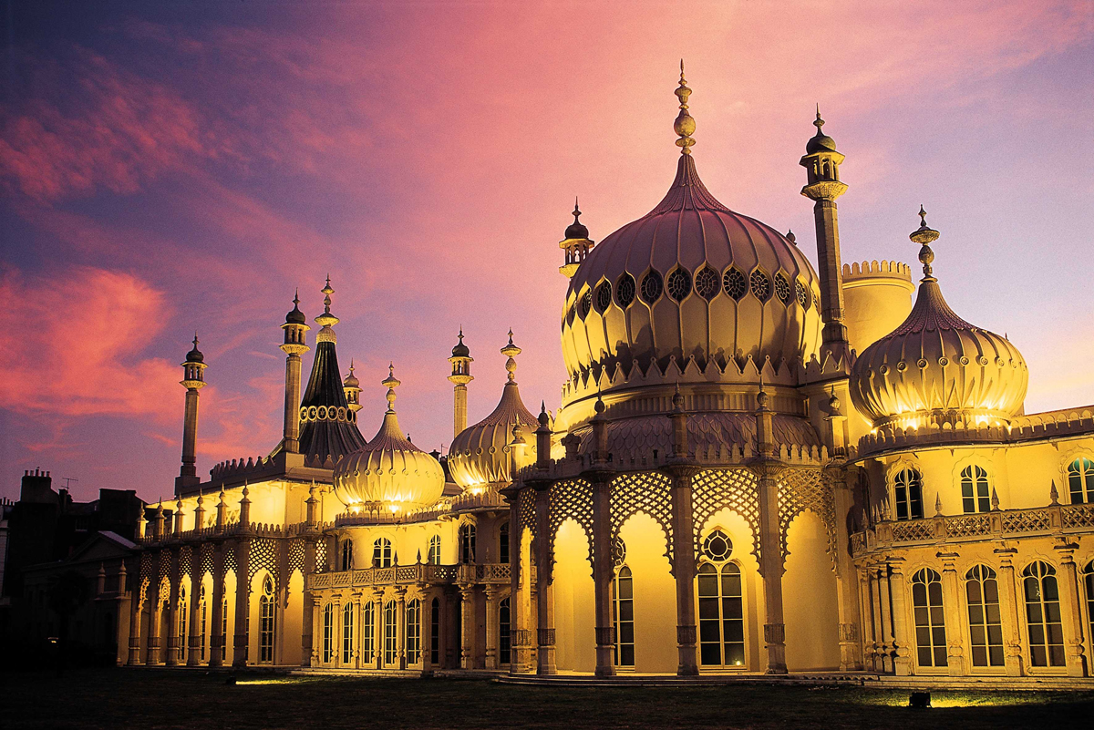 Royal Pavilion at Sunset. East Exterior view against a pink and pale blue sky. The Pavilion is lit by external yellow lightning