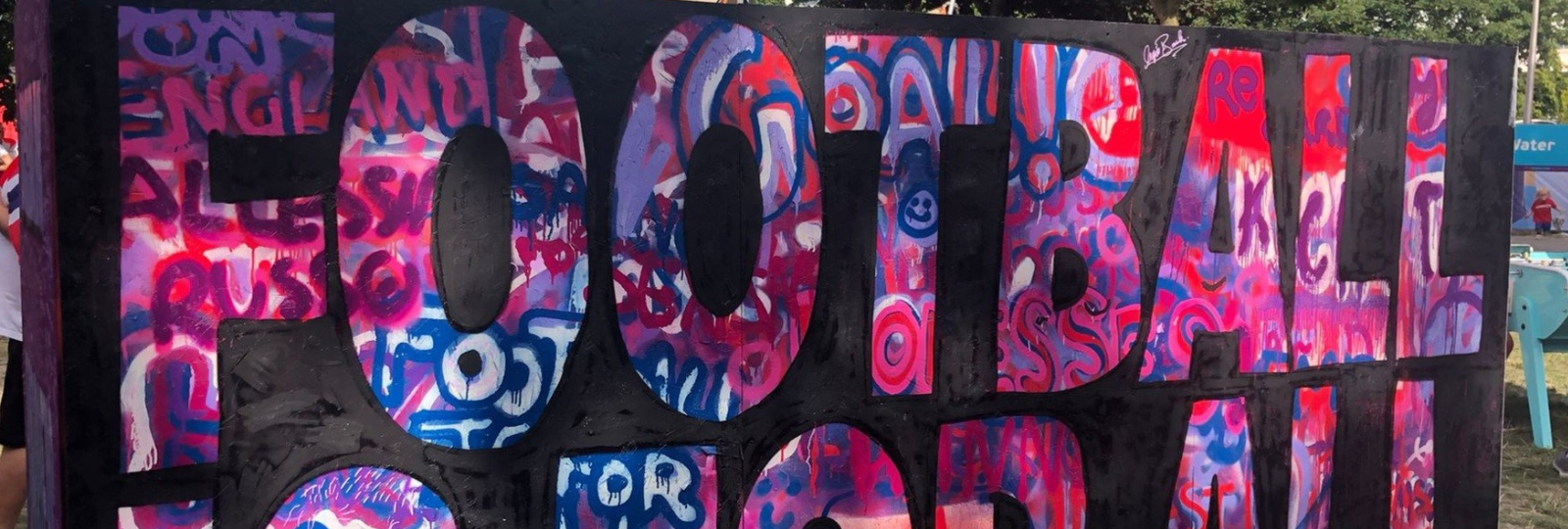 photograph of a sign saying football written in graffiti style