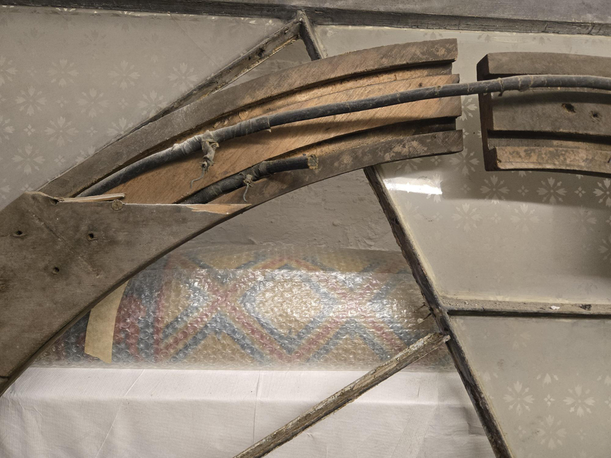 Electrical ring from Fish Bowl Chandelier in Long Gallery. An aged wooden frame has an opening to reveal electrical piping within