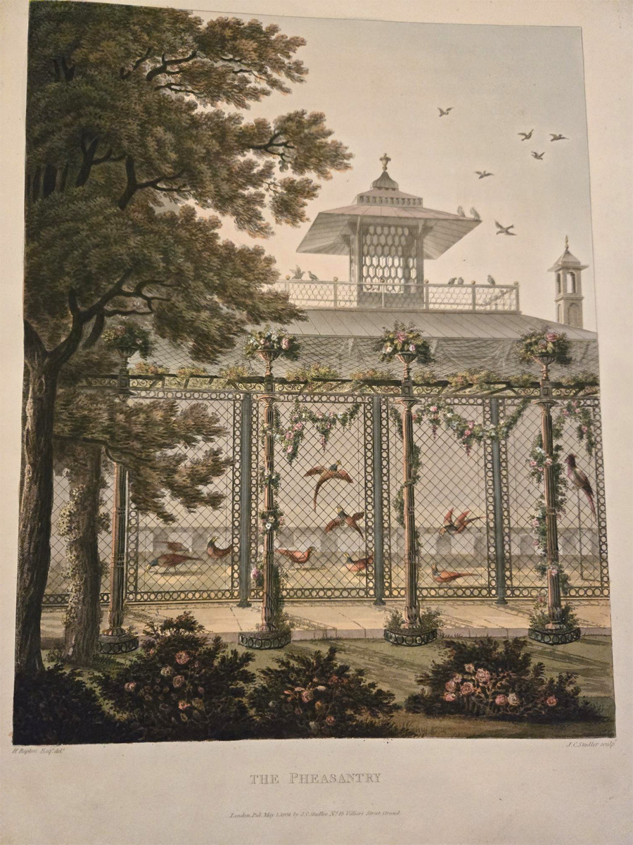 Extract from Humphrey Reptons Red Book- Proposed Bird House The Pheasantry. A colour drawing of a birdhouse, it is large in size, similar to a small building. It has grates for the sides and an elaborate roof. Birds are flying within the building. A tall tree is in the foreground in front of the bird house to the left. Floral bushes are in front of the house.
