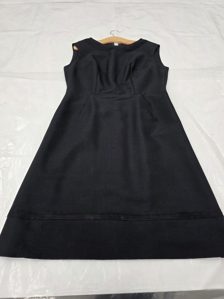 The after image of a significantly mouldy black dress. The dress is plain black and clean