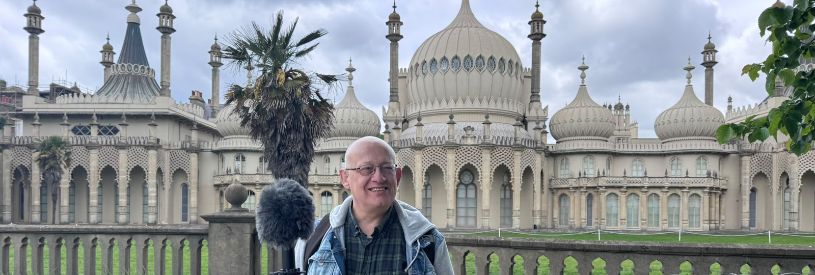 Peter Bourne elm garden audio tour. A man stands in the Royal Pavilion garden with a large microphone